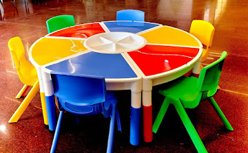 Pre-school modular circular activity table with colored chairs