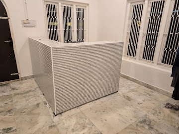 Modern L-shaped reception desk with white fluted ribbed front fitted in Vijayawada
